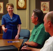 Photo showing a woman Vocational Administrator conducting a meeting at a conference table